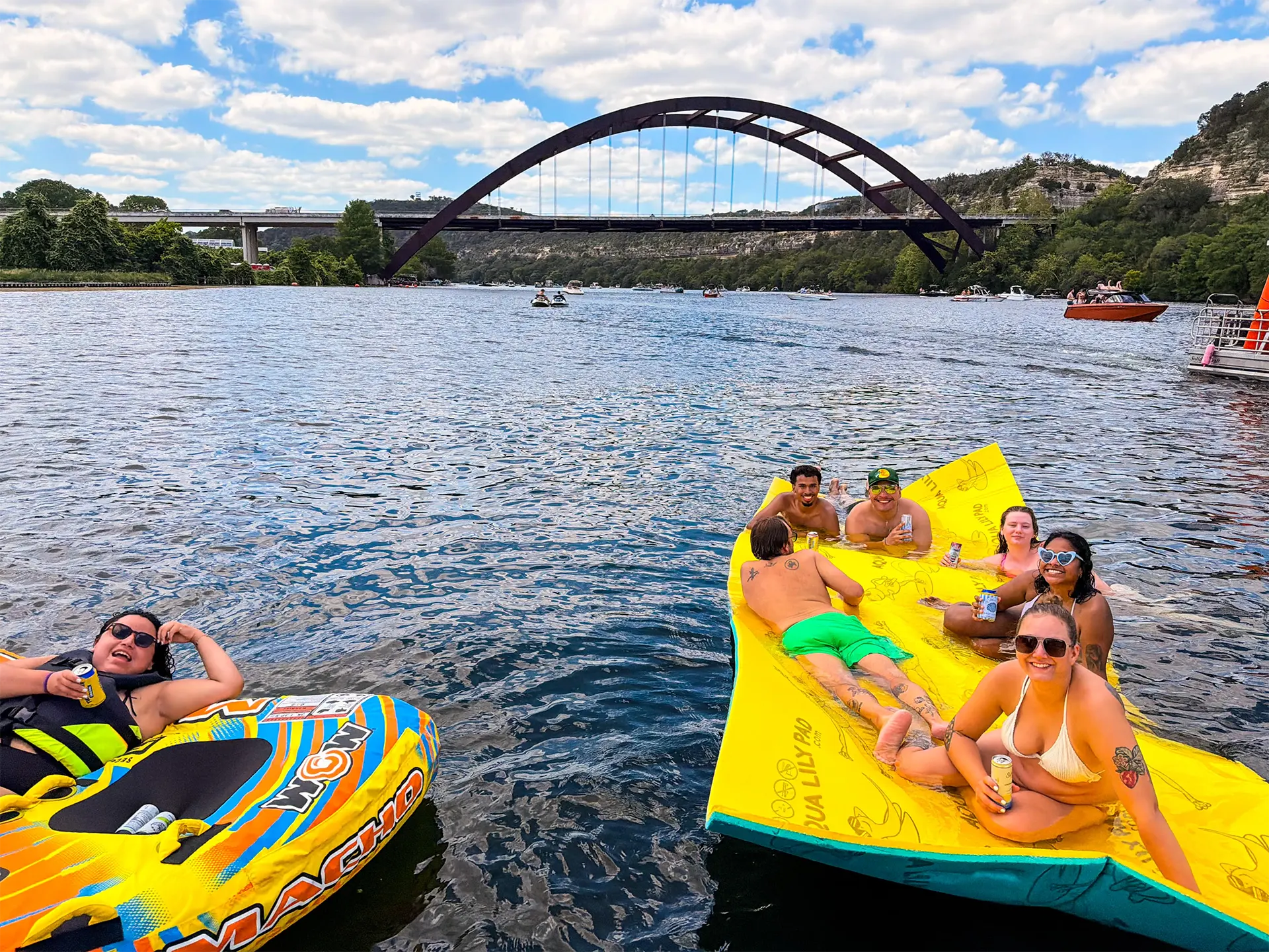 Group relaxing on an aqua lily pad during a Lake Austin boat party